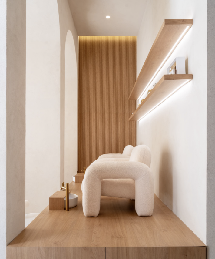 Zona de espera con butacas y estanterías de madera